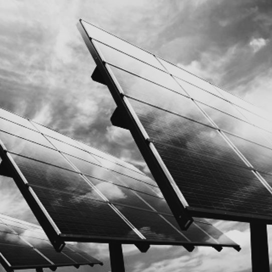 Large galvannealed steel solar panels in a field reflecting sunlight