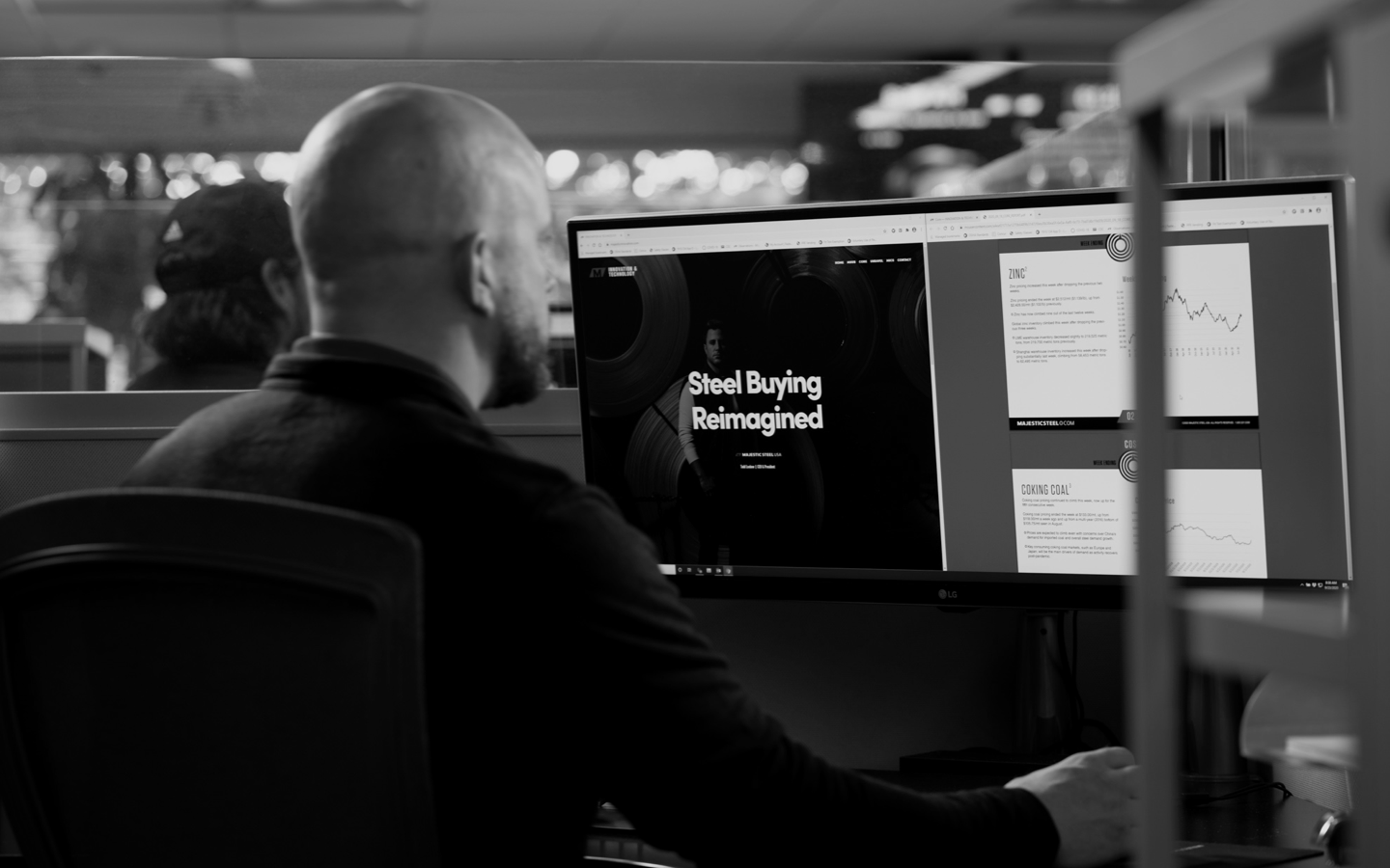 black and white image of a majestic steel associate working on his computer